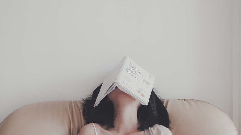 Girl with a book on her face